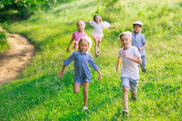 istock Kids, children running on meadow in summer's sunlight 1259890599
