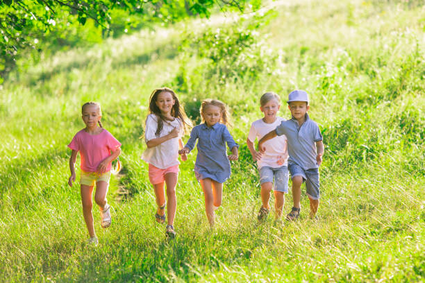 istock Kids, children running on meadow in summer's sunlight 1259890627