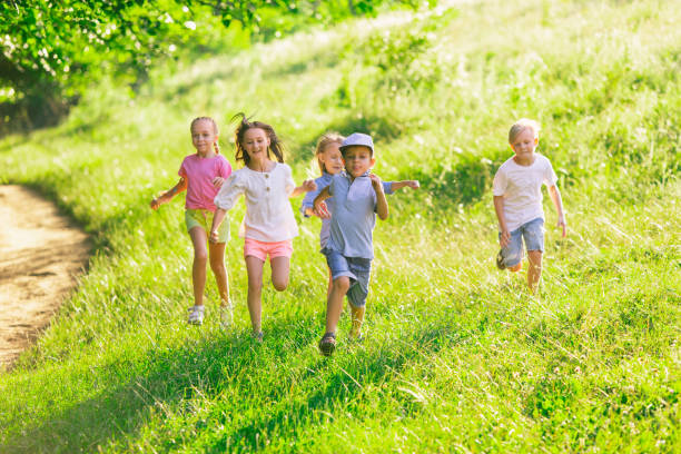 istock Kids, children running on meadow in summer's sunlight 1259890633