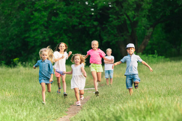 istock Kids, children running on meadow in summer's sunlight 1259890639