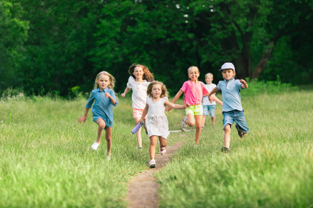 istock Kids, children running on meadow in summer's sunlight 1259890644