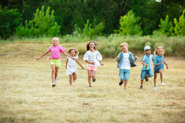 istock Kids, children running on meadow in summer's sunlight 1259890655