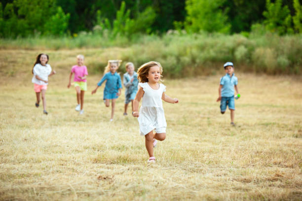 istock Kids, children running on meadow in summer's sunlight 1259890656