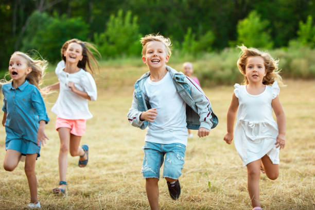 istock Kids, children running on meadow in summer's sunlight 1259890665