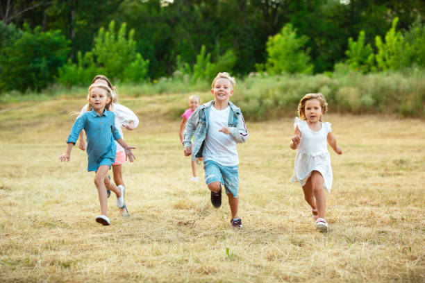 istock Kids, children running on meadow in summer's sunlight 1259890666