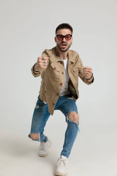 istock angry young man in jacket holding fists up and striking 1259895064