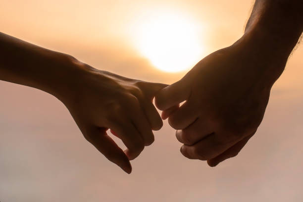 hands of a man and a woman a couple hold each other's hands in the background of the sunset couple relationship stock pictures, royalty-free photos & images