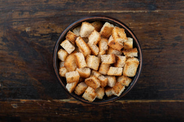 istock Crispy croutons in a bowl on a wooden background. 1259906378