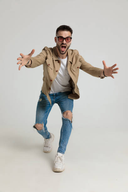 upset young casual guy in jacket running and catching