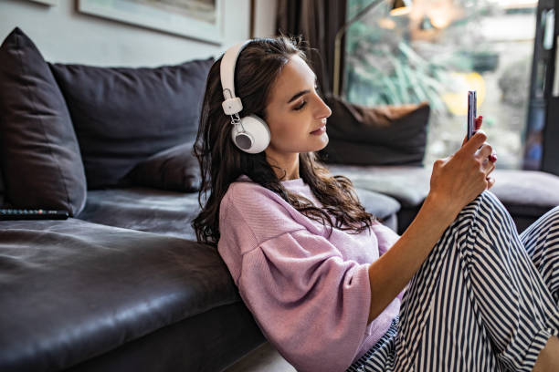 mujer joven disfrutando en casa - attractive female only young women music living room fotografías e imágenes de stock