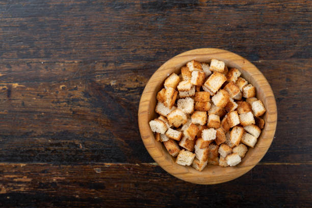istock Crispy croutons in a bowl on a wooden background. 1259908633