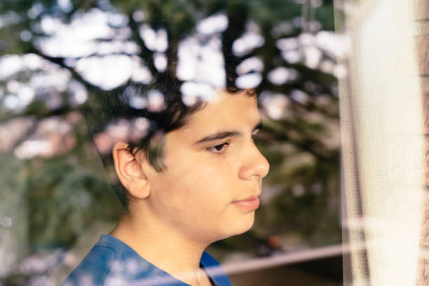 Teenage Boy Looking Through Window