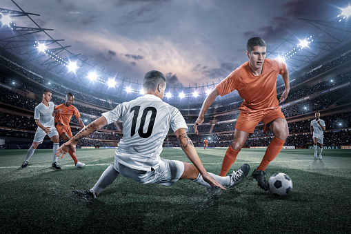 Strong kick. Professional man, football player in sports team uniform running over soccer field background in neon light. Concept of active life, team game, sport, healthy lifestyle, competition, ad