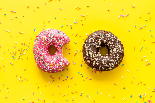 istock Colorful donuts pink and chocolate icing. Flat lay of bakery, above view 1259928011