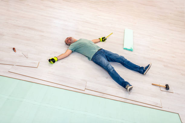 Tired Mature Man Lying on Freshly Installed Laminate Floor