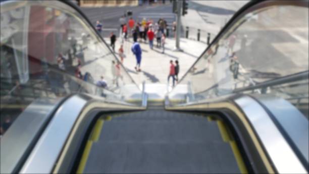 Perspective view thru escalator, defocused unrecognizable group of people on road intersection crosswalk on Strip of Las Vegas, USA. Anonymous blurred pedestrians on walkway in crowded urban downtown