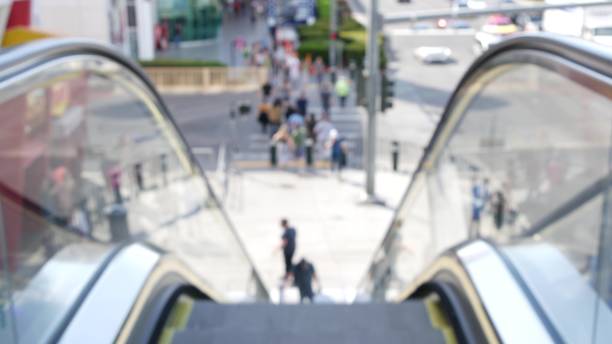 istock Perspective view thru escalator, defocused unrecognizable group of people on road intersection crosswalk on Strip of Las Vegas, USA. Anonymous blurred pedestrians on walkway in crowded urban downtown 1259945790