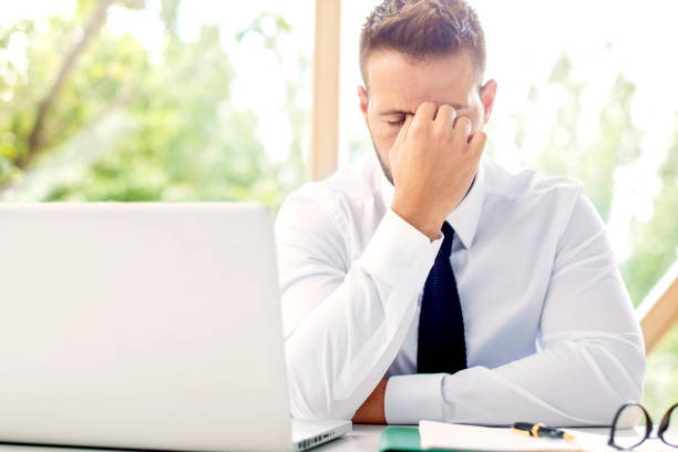 istock Stressed businessman having pain in his head while working at the office 1259950176