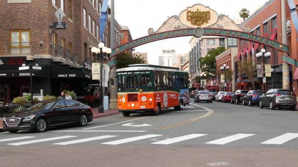 ガスランプクォーター歴史的な入り口アーチサイン。オレンジレトロトロリー、旧市街観光ツアー。 - san diego trolley ストックフォトと画像