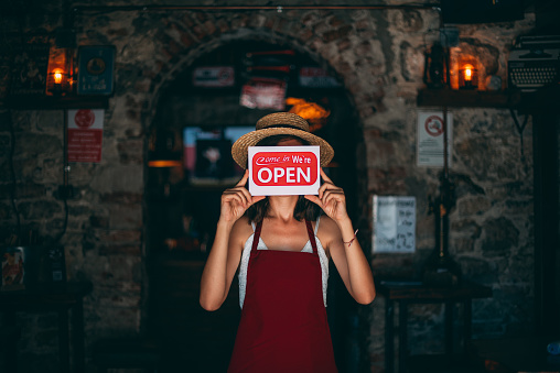 Woman Holding Open Sign in a Small Business After Covid-19