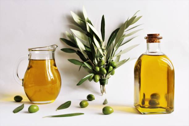 Olive oil Olive oil glass bottle and olive oil jar with bouquet of olive branches and green olives. photo isolate on white front view copy space olive oil pouring antioxidant liquid stock pictures, royalty-free photos & images