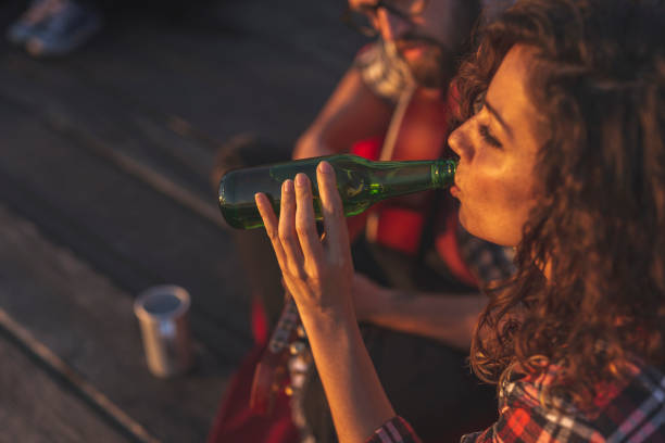 istock Couple playing the guitar and drinking beer 1259973563