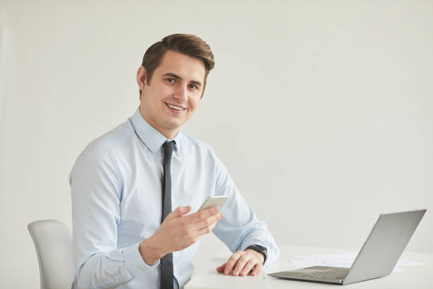 istock Smiling Businessman at Workplace in White Office 1260010284