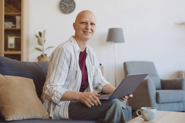 istock Smiling Bald Woman Using Laptop at Home 1260017296