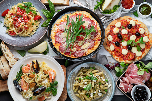 Italian food  on dark background with pasta, pizza, top view,