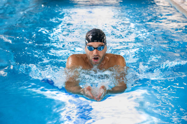 nadador masculino deportivo nadando en la piscina, najillera natación. vista frontal, técnicas de natación. - braza fotografías e imágenes de stock