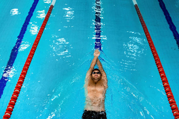 istock Swimmer floating in the swimming pool, top view. Man swimming on back 1260022841