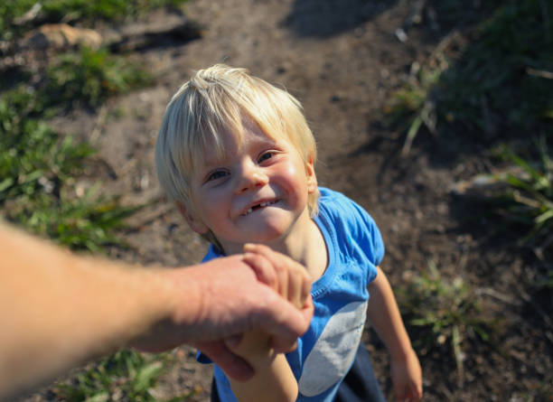 istock A young boy while hiking in the mountains holds his fathers hand 1260024456