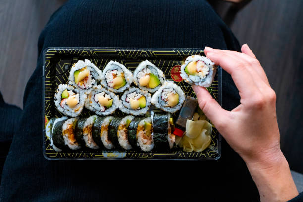 istock Young Woman Eating Sushi 1260046103