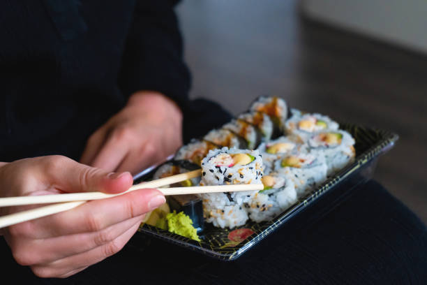 istock Young Woman Eating Sushi 1260046201