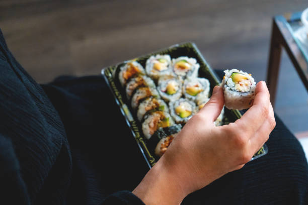 istock Young Woman Eating Sushi 1260046207