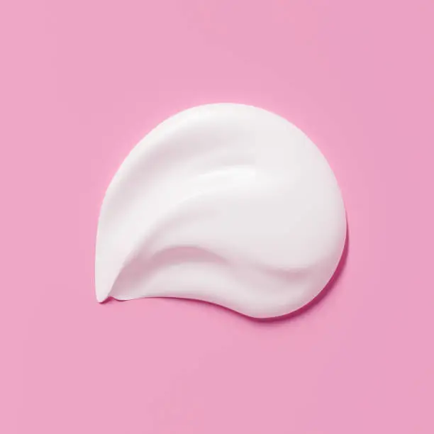 Photo of Cosmetic product smear white moisturizing lotion isolated on pink, squeezed out and smeared portion of skincare cream product testing. 3d rendering