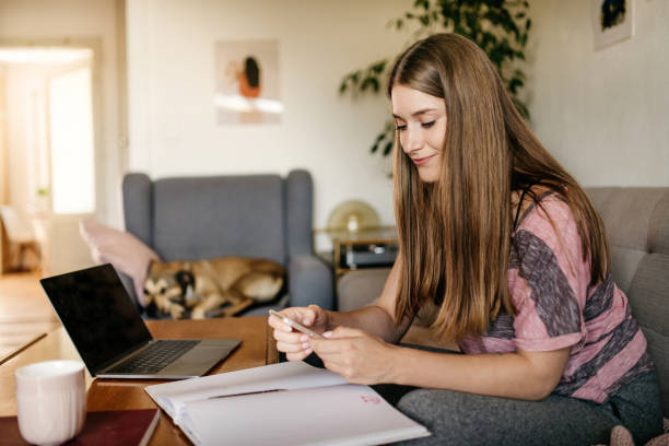 istock Young female checking the phone while working from home 1260055918