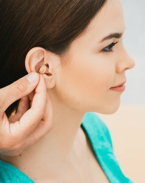 istock Young patient with Intra-ear hearing aid, close-up on female ear. The hearing solution, audiologist inserting hearing aid 1260061556
