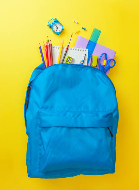 istock School bag. Backpack with supplies for school on yellow background. Copy space for text 1260065518