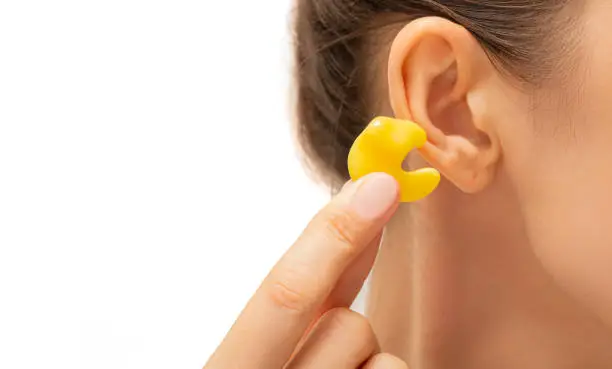 Photo of earplugs for noisy places, personally molded earplugs on ear close-up