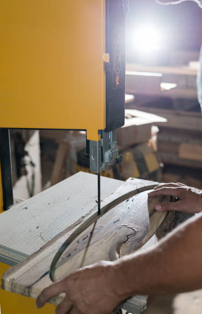 istock Carpenter hands working on band saw with wooden shape to create interior products. 1260106513