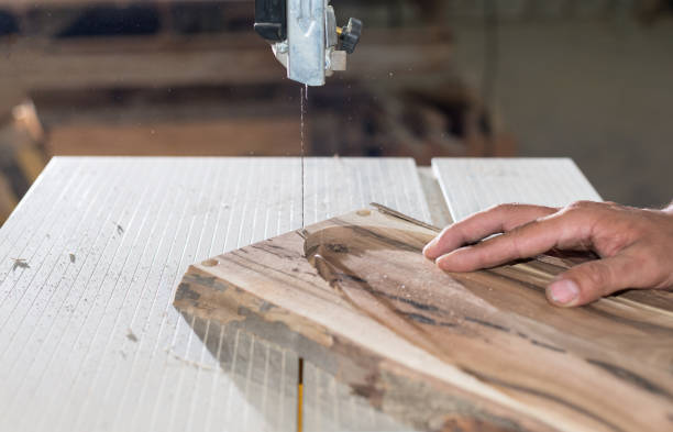 istock Carpenter hands working on band saw with wooden shape to create interior products. 1260107038