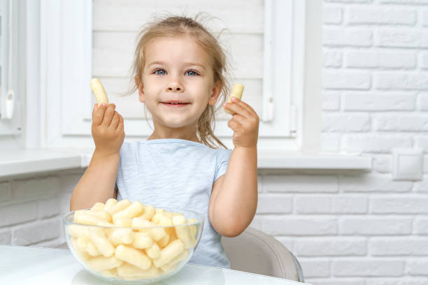 istock child eating corn sticks at the kitchen table 1260133386