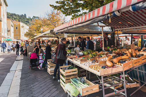 Nice, France - October 21 2017.\n\nThe famous Marche Aux Fleurs Cours Saleya in Place Charles Felix. Fresh fruits and colourful vegetables lie on the stands as the dealers set the goods prices