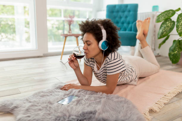 mulher ouvindo a música e relaxando em casa - lying on front joy enjoyment happiness - fotografias e filmes do acervo