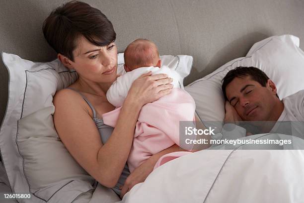 Foto de Mãe Cuddling Bebê Recémnascido Na Cama Em Casa e mais fotos de stock de Bebê - Bebê, Dormindo, Mãe