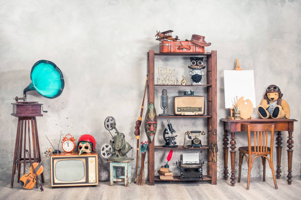 collection of antique media devices, writers tools, gramophone, film projector, old teddy bear toy with canvas blank on easel, travel bag front concrete wall background. vintage style filtered photo - radio gramophone imagens e fotografias de stock