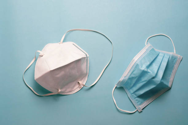 istock White and blue surgical face mask on blue background. 1260176508