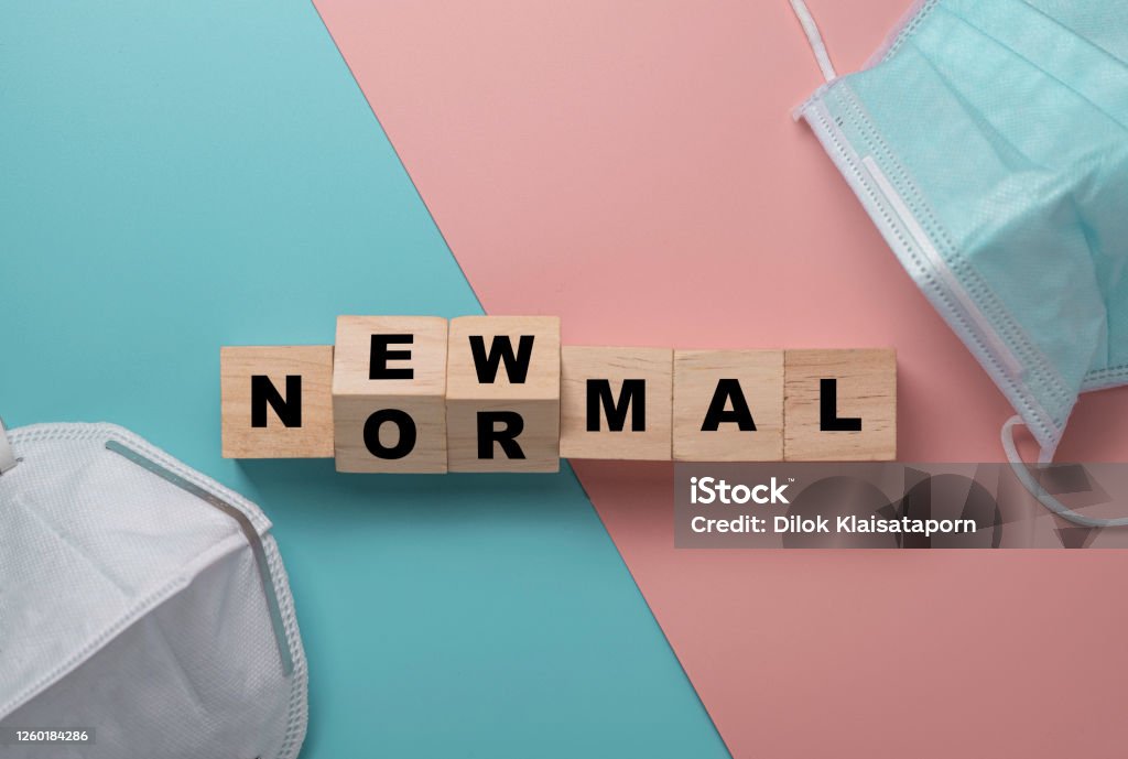Flat lay of flipping wooden block cubes for new normal wording with surgical mask. The world is changing to balance it into new normal include business , economy , environment and health. Adaptation - Concept Stock Photo