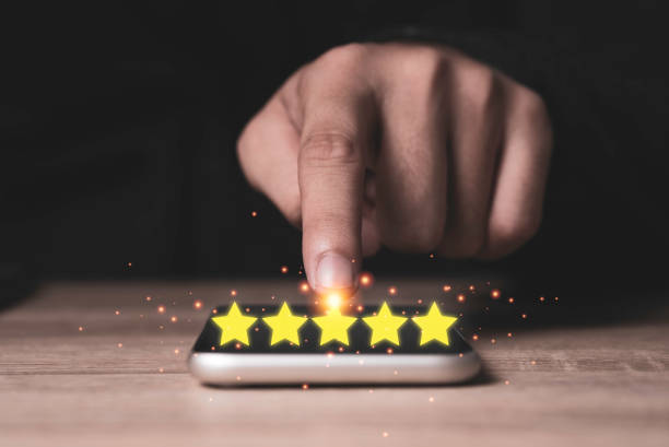 Hand pointing five yellow stars on mobile phone to customer evaluates products and services. Customer satisfaction and marketing survey rating concept. Hand pointing five yellow stars on mobile phone to customer evaluates products and services. Customer satisfaction and marketing survey rating concept. high fidelity stock pictures, royalty-free photos & images